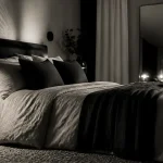 Noir et blanc chambre chaleureuse : lit lin, lampe noire, rideaux écrus